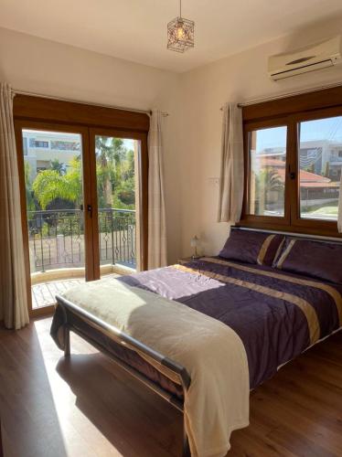 a bedroom with a bed and a large window at EPISKOPI VILLA, Luxury 4 Bedroom with Pool - Limassol in Limassol