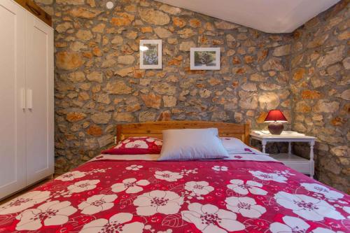 een slaapkamer met een bed en een stenen muur bij Holiday home in Polje/Krk/Insel Krk 36486 in Polje
