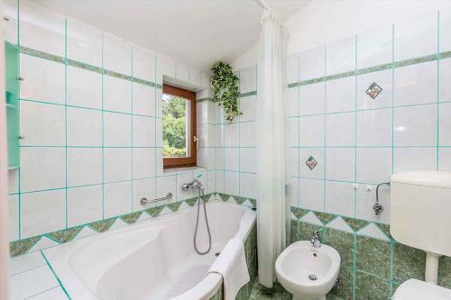 a bathroom with a tub and a toilet and a sink at Apartment in Viskovo 31060 in Viskovo