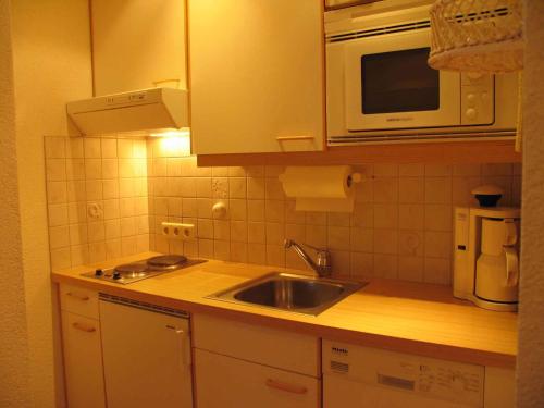 a kitchen with a sink and a microwave at Apartments in Dienten am Hochkönig 225 in Dienten am Hochkönig