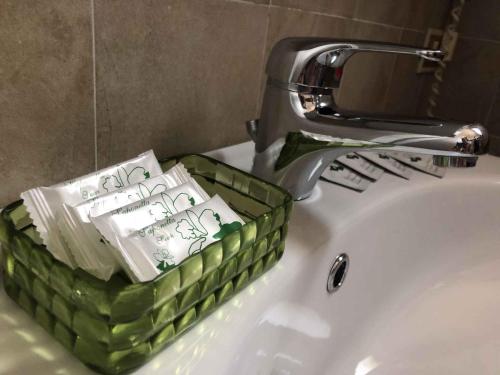 a green basket sitting on a sink next to a faucet at Apartments in Sirmione/Gardasee 22559 in Sirmione