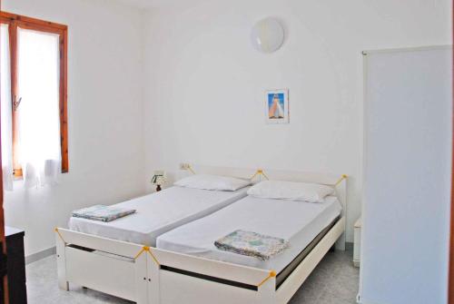 a white bedroom with a bed with white sheets at Apartments in Capoliveri/Insel Elba 23660 in Capoliveri