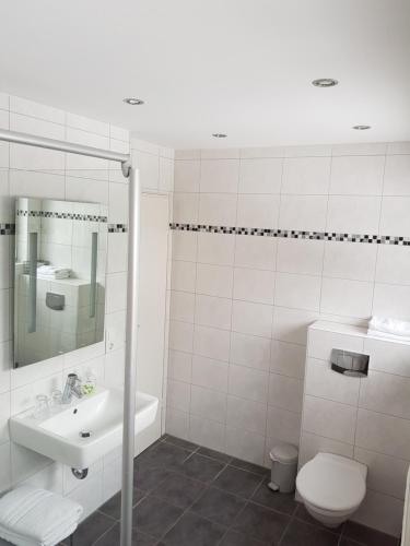 a white bathroom with a sink and a toilet at Berghotel Natura Bed & Breakfast in Winterberg
