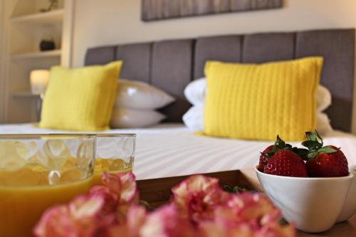 a table with a bowl of strawberries and a bed at Wallace View Apartment in Stirling