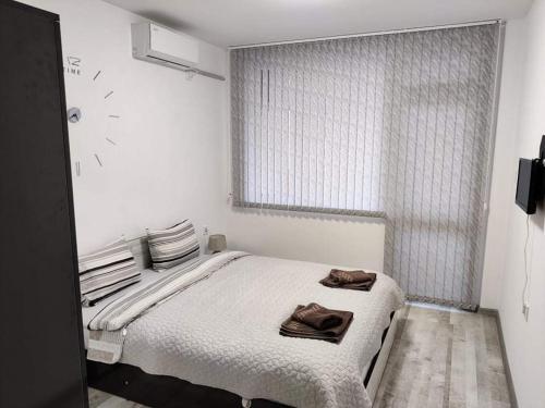 a white bedroom with a bed and a window at Apartment Anelia 3 in Plovdiv