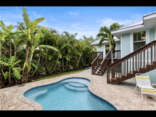a swimming pool in front of a house at AMI/Holmes Beach - 3/2 Home - Private Heated Pool and Yard - walk to beach in Holmes Beach