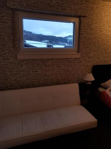 a living room with a couch under a window at Berghotel Natura Bed & Breakfast in Winterberg