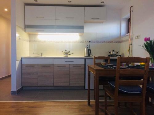 uma cozinha com um lavatório e uma mesa com uma mesa; em Apartments in Siofok/Balaton 36443 em Siófok
