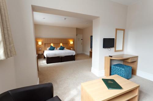 a hotel room with a bed and a tv at Links Country Park Hotel in Cromer