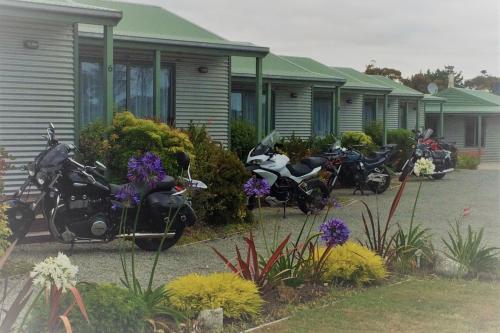 a row of motorcycles parked outside a row of houses at Omau Settlers Lodge Motel in Westport