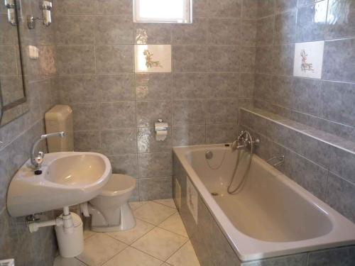 een badkamer met een wastafel, een bad en een toilet bij Apartments in Balatonmariafürdo 19567 in Balatonmáriafürdő