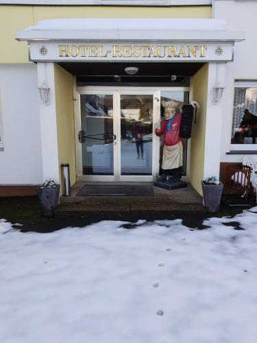 a statue of a man standing outside of a building at Berghotel Natura Bed & Breakfast in Winterberg