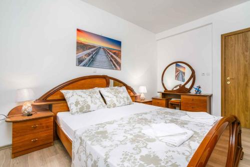 een slaapkamer met een groot bed en een spiegel bij Apartments in Cizici/Insel Krk 31083 in Čižići