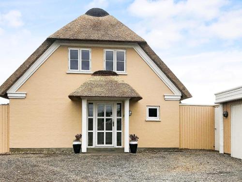 a large yellow house with a thatched roof at 8 person holiday home in Bl vand in Blåvand