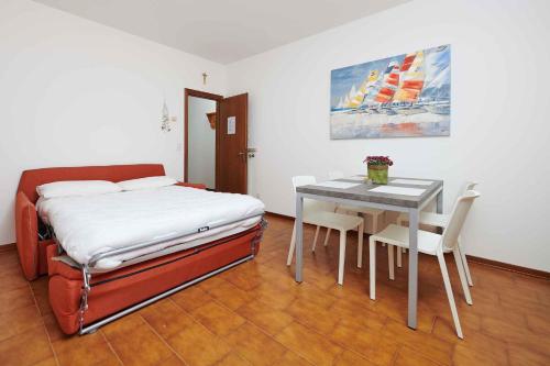 a bedroom with a bed and a table with chairs at Apartments in Malcesine/Gardasee 22016 in Assenza di Brenzone
