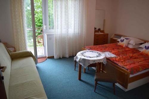 een slaapkamer met een bed, een tafel en een raam bij Apartment in Selce 5869 in Selce