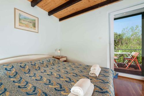 a bedroom with a bed and a balcony with a chair at Apartments in Bozava/Insel Dugi Otok 7831 in Božava