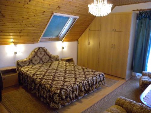 een slaapkamer met een bed en een kroonluchter bij Apartment in Badacsony/Balaton 18014 in Badacsonytomaj