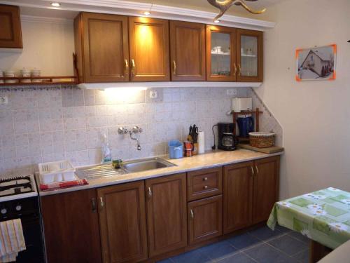 una cocina con armarios de madera y fregadero en Holiday home in Balatonendred 33661, en Balatonendréd