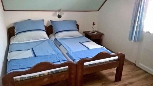 1 dormitorio con 2 camas individuales y almohadas azules en Holiday home in Balatonendred 33661, en Balatonendréd