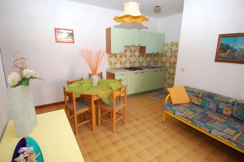 uma cozinha e sala de jantar com uma mesa e um sofá em Apartments in Rosolina Mare 24848 em Rosolina Mare