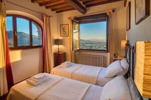 um quarto com 2 camas e uma grande janela em Holiday home in Castiglion Fiorentino 23605 em Castiglion Fiorentino