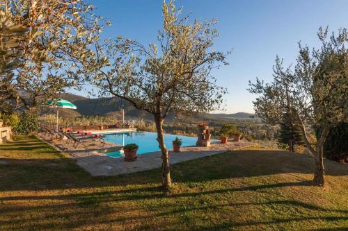 uma piscina com árvores e uma pessoa ao lado dela em Holiday home in Castiglion Fiorentino 23605 em Castiglion Fiorentino