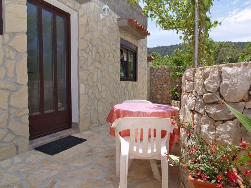a table and chairs sitting in front of a house at Apartment in Veli Losinj 33734 in Veli Lošinj