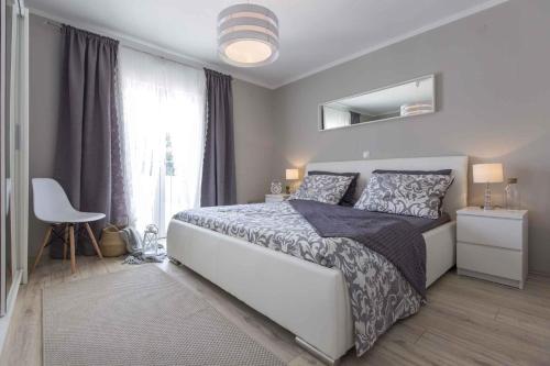 sypialnia z dużym łóżkiem i oknem w obiekcie Holiday home in Becici 35609 w mieście VeliGolji