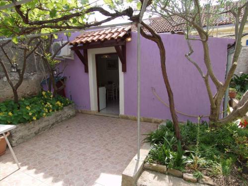a purple house with a purple wall and a patio at Apartment in Veli Losinj 14933 in Veli Lošinj