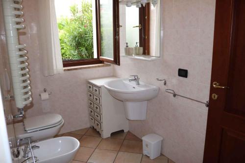 uma casa de banho com um lavatório, um WC e um espelho. em Apartment in Bardolino/Gardasee 21881 em Bardolino