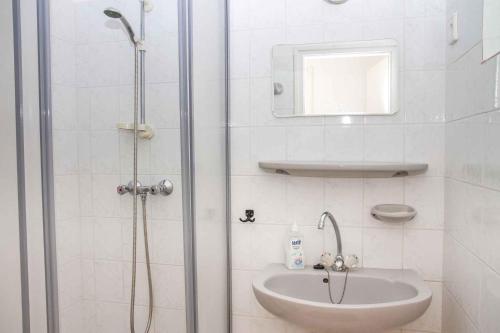 baño blanco con ducha y lavamanos en Holiday home in Balatonmariafürdo 35399 en Balatonmáriafürdő