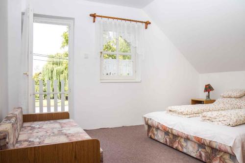 1 dormitorio con 2 camas y ventana en Holiday home in Balatonmariafürdo 35399 en Balatonmáriafürdő