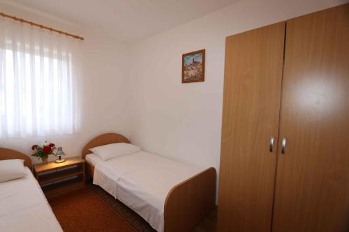 シロにあるTwo-Bedroom Apartment in Silo IIの小さなベッドルーム(ベッド2台、キャビネット付)