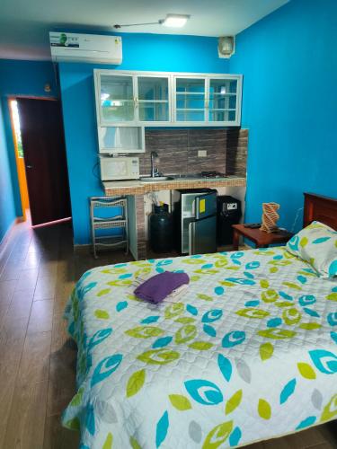a bedroom with a bed and a blue wall at Hosteria Mar de Plata in Cabuyal