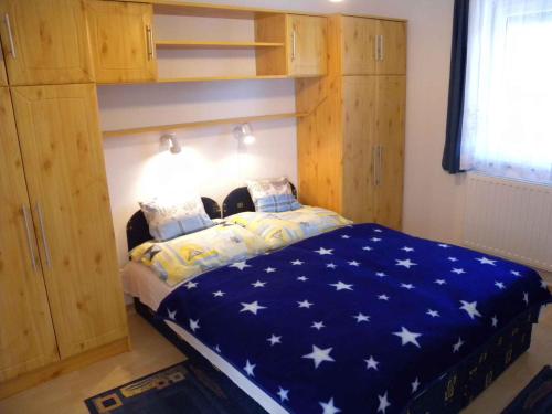 ザラカロシュにあるApartments in Zalakaros 20675のベッドルーム1室(白い星の青い毛布付きのベッド1台付)