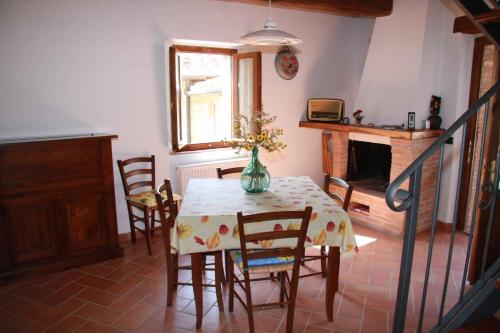a dining room with a table and chairs and a fireplace at Holiday home in Montieri/Toskana 34273 in Montieri
