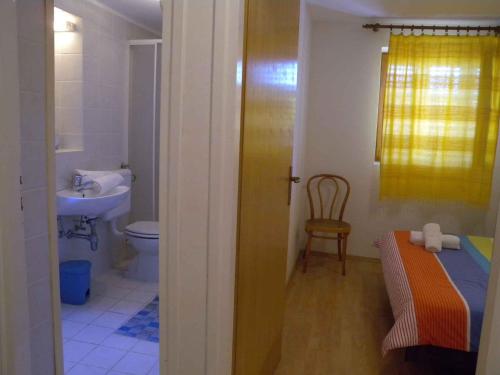 y baño con cama, lavabo y aseo. en Dobrinj Apartment 2, en Dobrinj