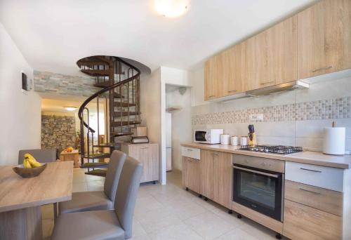 a kitchen with wooden cabinets and a table and a dining room at Holiday home in Krsan 34373 in Kršan