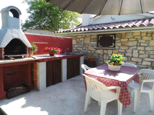 a patio with a table and an outdoor oven at Holiday home in Krsan 34600 in Kršan