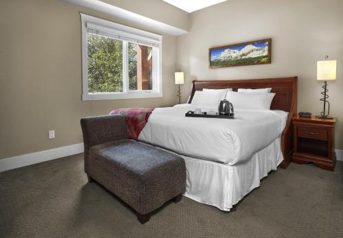 a bedroom with a large bed and a chair at Star Suite -Luxurious condo with 3 fireplaces, and open Pool! in Canmore