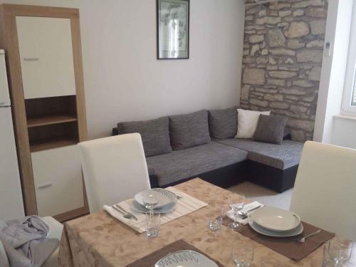 ein Wohnzimmer mit einem Tisch und einem Sofa in der Unterkunft Apartment in Banjole/Istrien 34141 in Banjole
