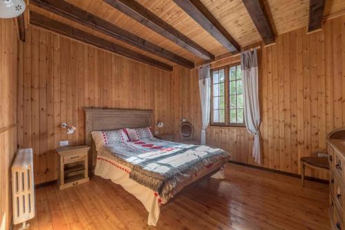 een slaapkamer met een bed in een houten kamer bij Holiday home in Molina in Lenzumo di Concei