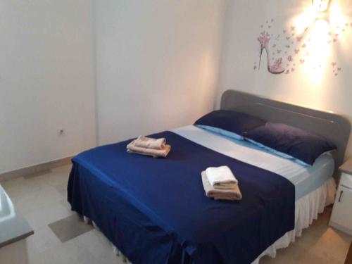 een slaapkamer met een blauw bed en handdoeken bij Apartment in Kožin in Kožino