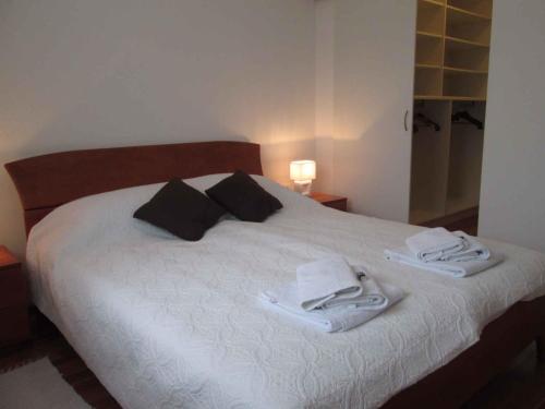 a bedroom with a white bed with towels on it at Holiday home in Grizane 5170 in Grižane