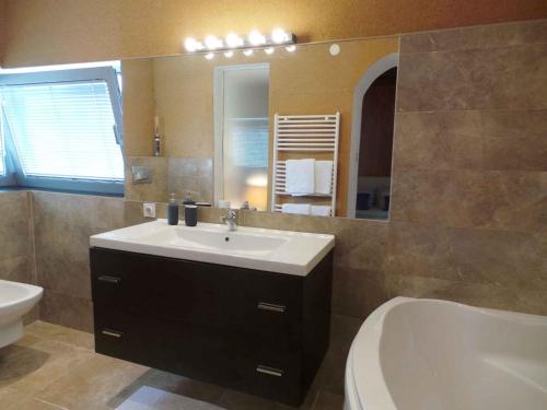 a bathroom with a sink and a tub and a mirror at Apartments in Rovinj/Istrien 34602 in Rovinj