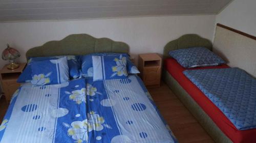 Apartments in Balatonvilagos/Balaton 26340 في بالاتونفيلاجوس: غرفة نوم بسريرين توأم مع لحاف ازرق