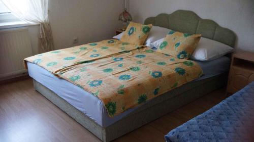 Apartments in Balatonvilagos/Balaton 26340 في بالاتونفيلاجوس: غرفة نوم مع سرير مع لحاف عليه