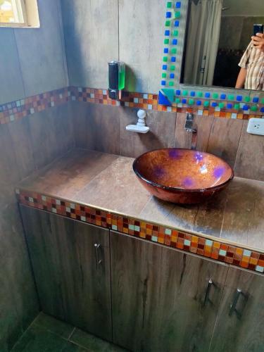 a bathroom sink with a wooden bowl on a counter at Hosteria Mar de Plata in Cabuyal