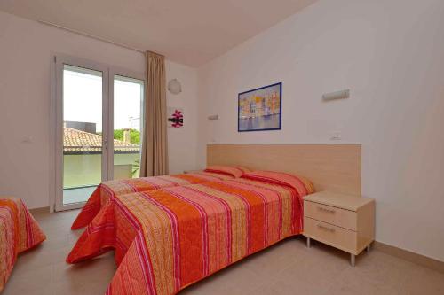 a bedroom with a bed and a large window at Apartments in Lignano 21707 in Lignano Sabbiadoro